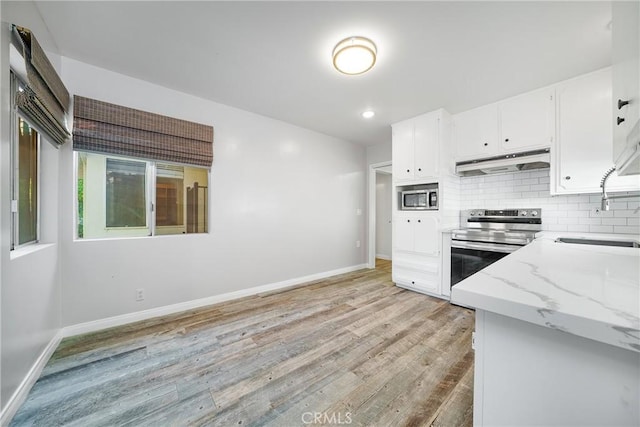 kitchen featuring light stone counters, sink, white cabinets, and stainless steel appliances