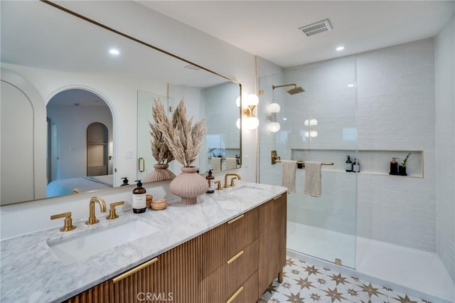 bathroom featuring vanity and a shower with door