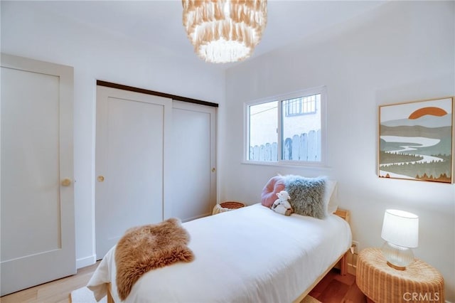 bedroom with an inviting chandelier and light hardwood / wood-style floors