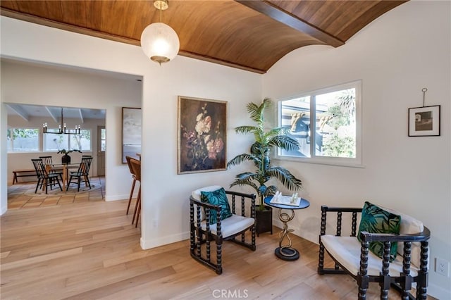 living area featuring lofted ceiling, brick ceiling, a chandelier, and hardwood / wood-style floors