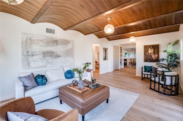 living room with light hardwood / wood-style floors, brick ceiling, and vaulted ceiling