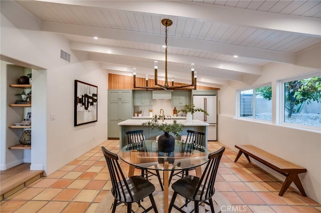 tiled dining room featuring lofted ceiling with beams and sink