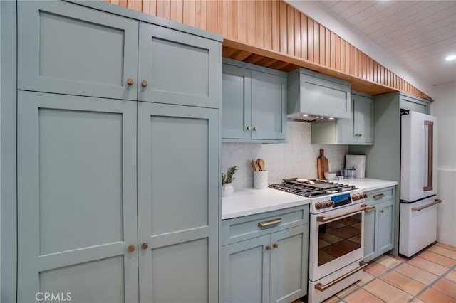 kitchen with high end appliances, premium range hood, light tile patterned floors, and decorative backsplash