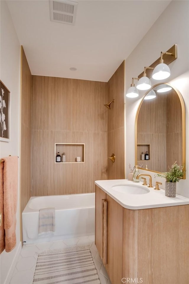 bathroom with tile patterned floors, washtub / shower combination, and vanity