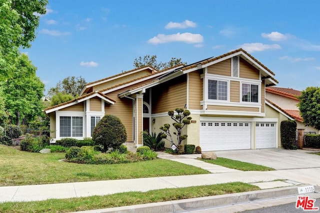 view of front of home featuring a garage and a front lawn