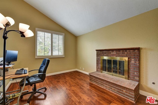 office area featuring a brick fireplace, dark hardwood / wood-style flooring, and vaulted ceiling