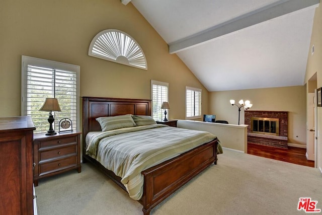 bedroom featuring a brick fireplace, light colored carpet, multiple windows, and beam ceiling