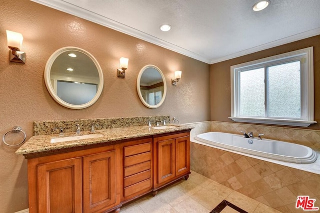 bathroom with ornamental molding, tiled tub, and vanity