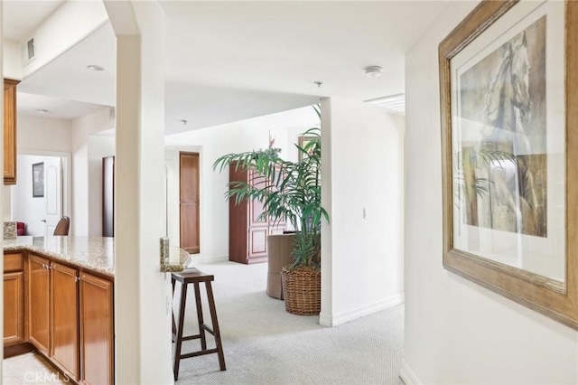 hall with light colored carpet