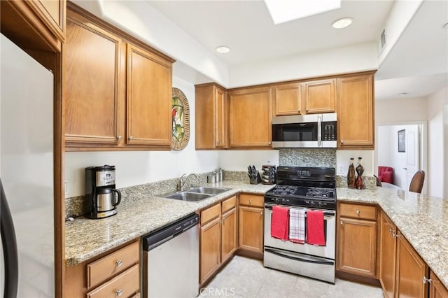 kitchen featuring light stone countertops, sink, and appliances with stainless steel finishes