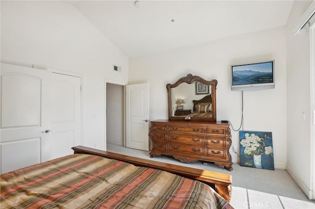 bedroom with a closet, carpet, and high vaulted ceiling