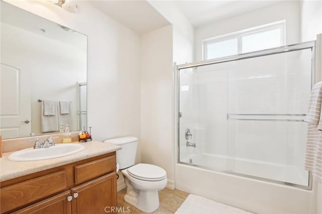 full bathroom featuring bath / shower combo with glass door, toilet, vanity, and tile patterned flooring