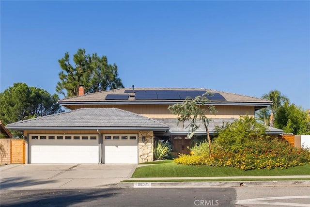 view of front of home with solar panels and a garage