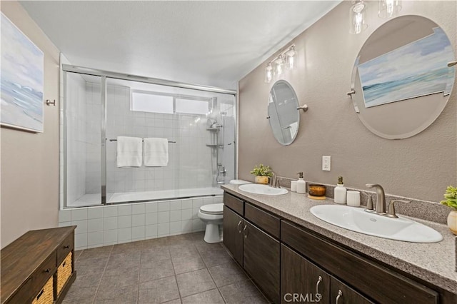 full bathroom featuring toilet, vanity, tile patterned floors, and shower / bath combination with glass door