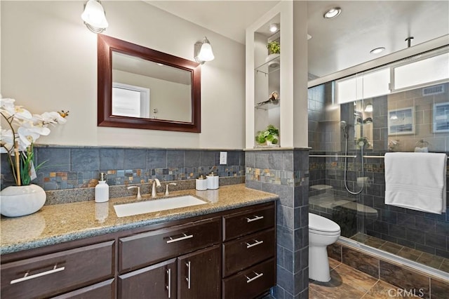 bathroom with toilet, a shower with shower door, and vanity