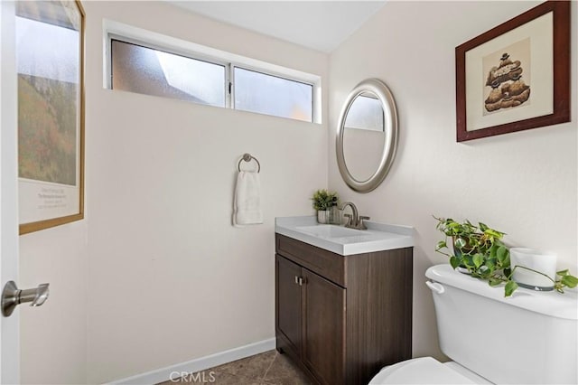 bathroom with toilet, vanity, and tile patterned flooring