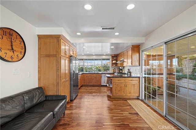 kitchen featuring decorative backsplash, dark wood-type flooring, and stainless steel appliances