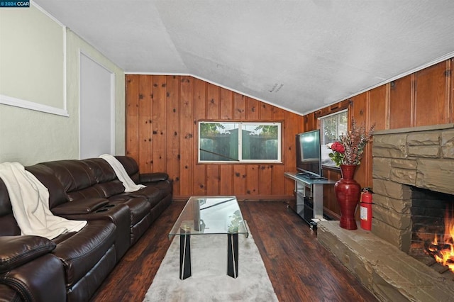 living room with wooden walls, dark hardwood / wood-style floors, a fireplace, vaulted ceiling, and ornamental molding