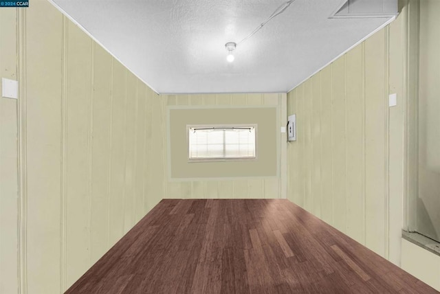 hallway featuring wood-type flooring and wood walls