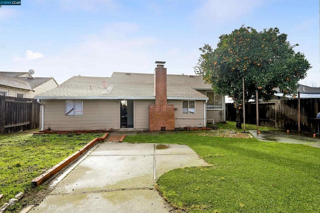 rear view of house with a patio area and a lawn