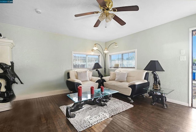 living room with dark hardwood / wood-style flooring and ceiling fan with notable chandelier