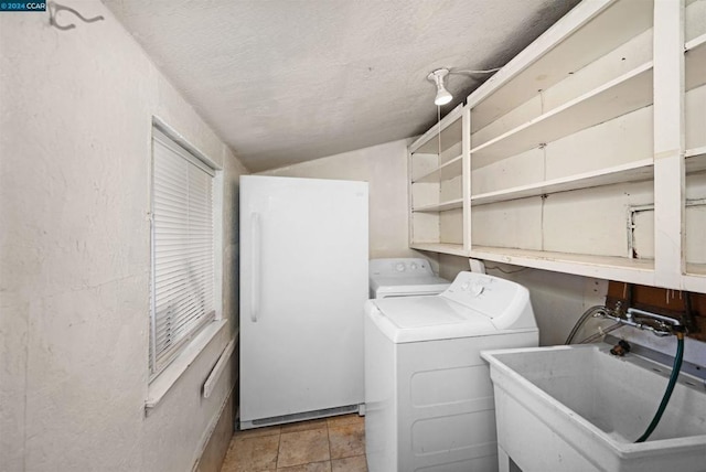 washroom featuring washer and dryer, sink, and a textured ceiling