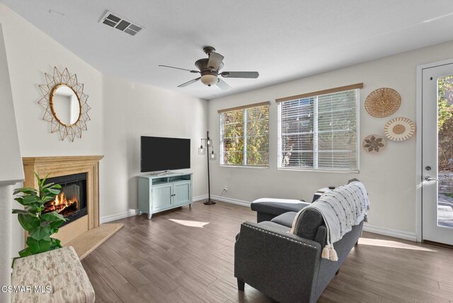 living room featuring ceiling fan, plenty of natural light, and dark hardwood / wood-style floors