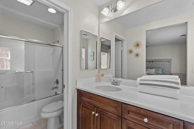 full bathroom featuring toilet, vanity, shower / bath combination with glass door, and a wealth of natural light