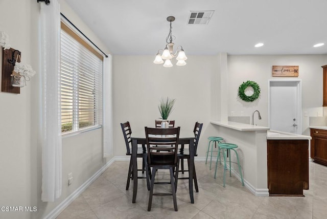 dining room featuring light tile patterned floors, sink, and a chandelier