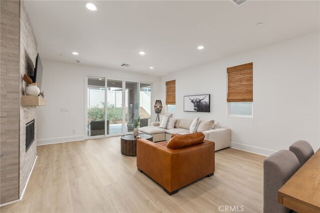 living room featuring light wood-type flooring and a fireplace