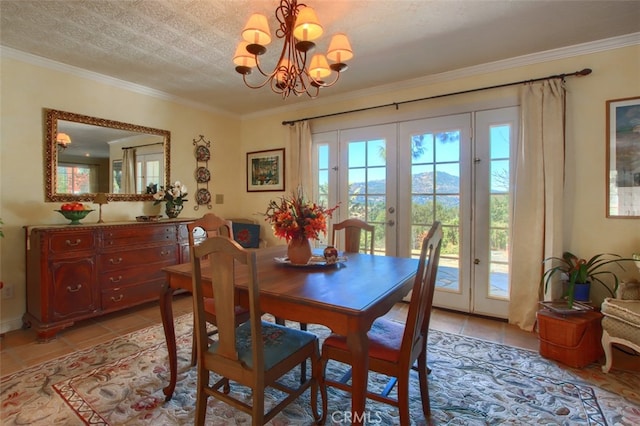 tiled dining room with a textured ceiling, crown molding, french doors, and a notable chandelier