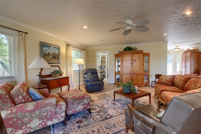 tiled living room featuring plenty of natural light, ceiling fan, ornamental molding, and french doors