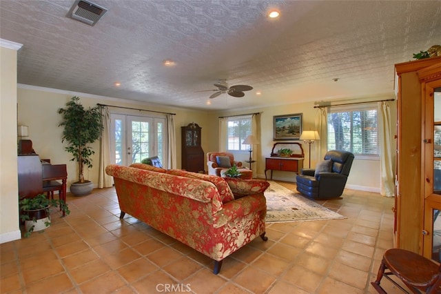 tiled living room with french doors, ceiling fan, ornamental molding, and plenty of natural light