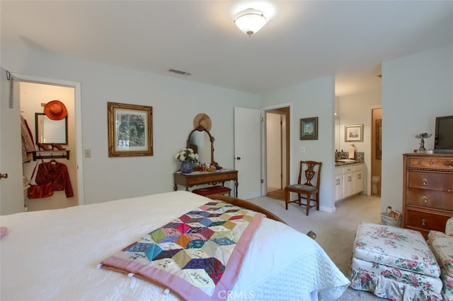 carpeted bedroom featuring connected bathroom