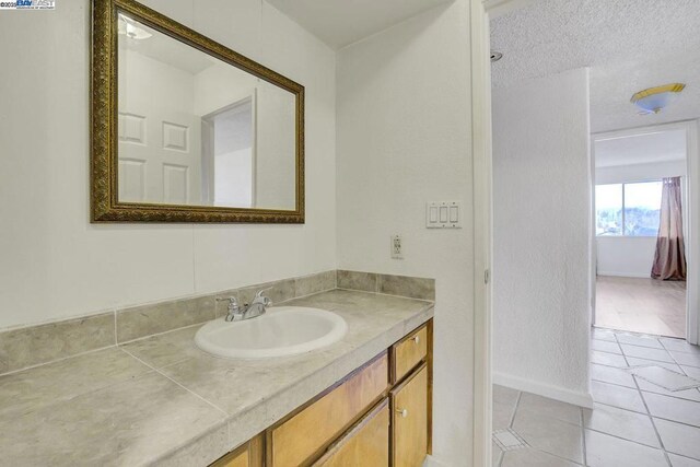 bathroom with vanity, tile patterned floors, and a textured ceiling