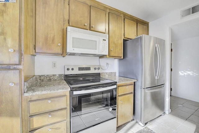 kitchen featuring light tile patterned floors and stainless steel appliances