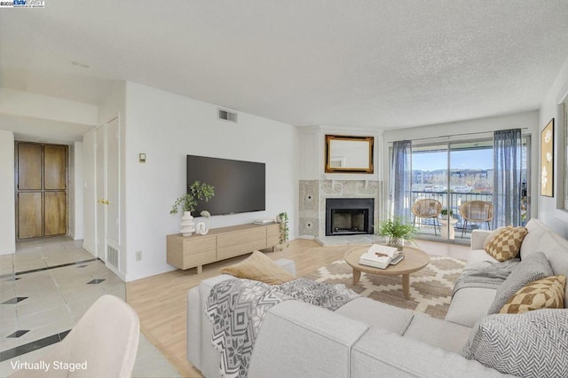 living room featuring a textured ceiling and light tile patterned floors