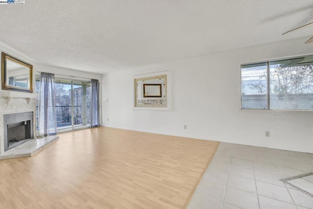 unfurnished living room with a textured ceiling and ceiling fan