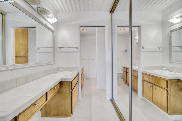 bathroom featuring toilet, tile patterned floors, and vanity