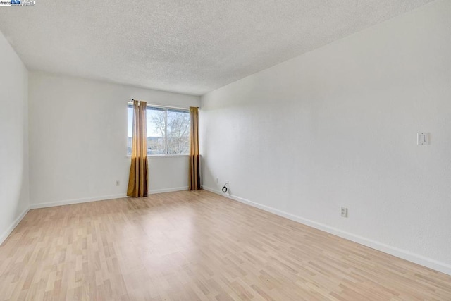 empty room featuring a textured ceiling and light wood-type flooring