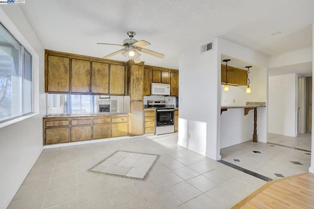 kitchen featuring decorative light fixtures, ceiling fan, range with electric cooktop, and light tile patterned flooring