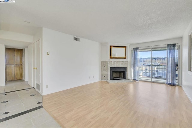 unfurnished living room featuring light tile patterned flooring and a textured ceiling