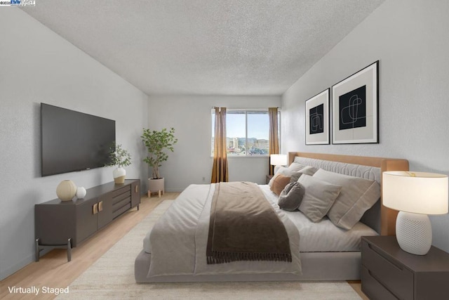 bedroom featuring a textured ceiling and light hardwood / wood-style floors