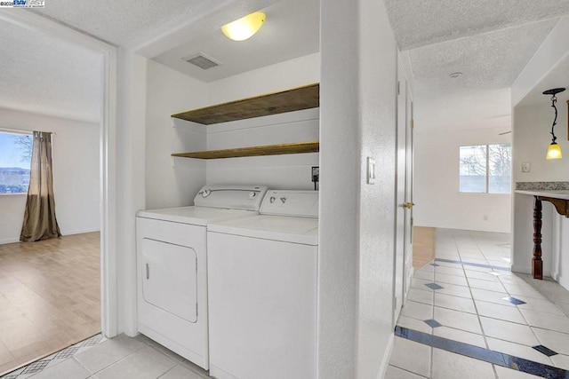 washroom with washing machine and dryer and light tile patterned floors