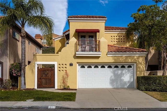 mediterranean / spanish house with a garage and a balcony