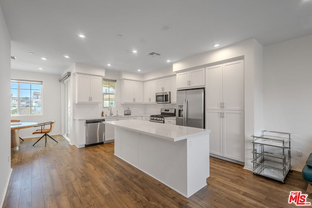 kitchen with appliances with stainless steel finishes, dark hardwood / wood-style flooring, and white cabinetry