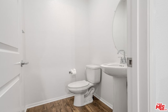 bathroom with hardwood / wood-style floors and toilet