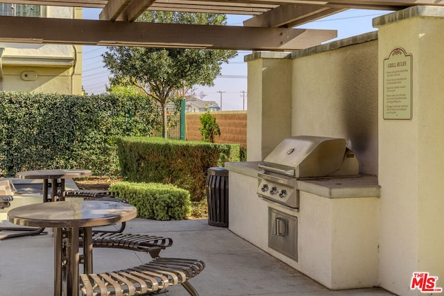 view of patio / terrace featuring exterior kitchen, a pergola, and grilling area