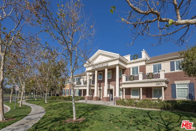 greek revival inspired property featuring a front lawn