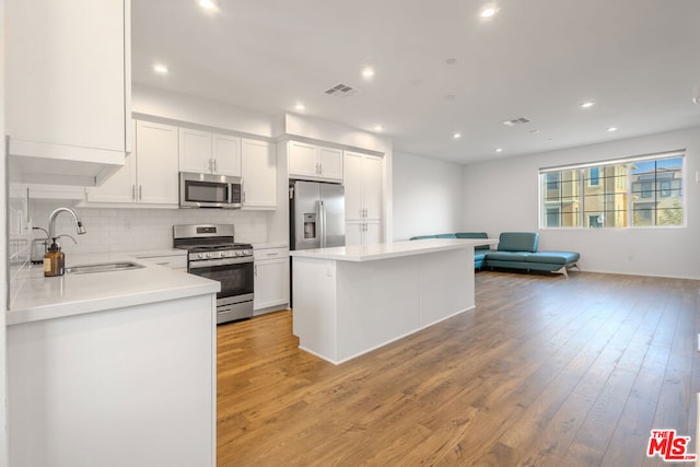 kitchen featuring sink, white cabinetry, appliances with stainless steel finishes, and light hardwood / wood-style flooring